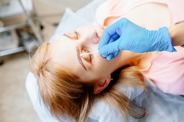 La giovane donna modella le sue sopracciglia con la matita per sopracciglia