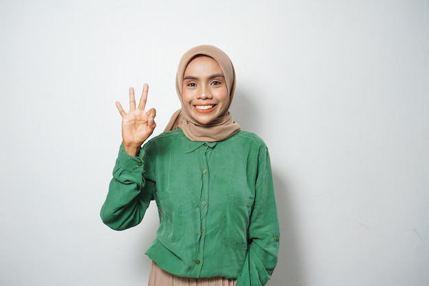 La giovane donna musulmana asiatica sorridente si è vestita nel segno giusto di gesto casuale