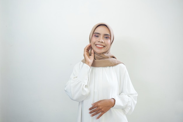 La giovane donna musulmana asiatica sorridente si sente sicura e gioiosa isolata su sfondo bianco