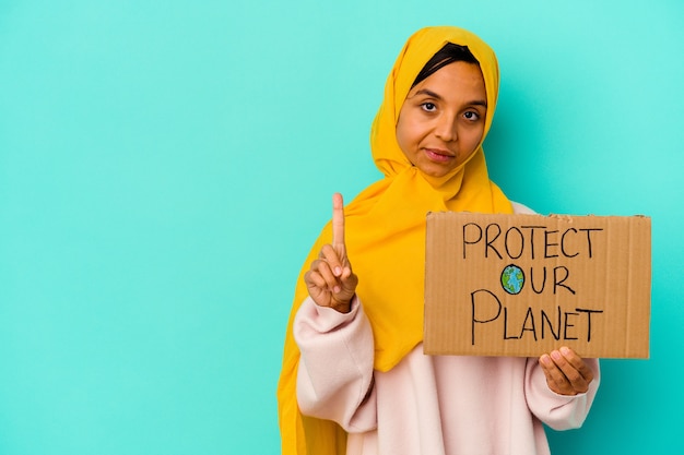 La giovane donna musulmana che tiene una protegge il nostro pianeta isolato