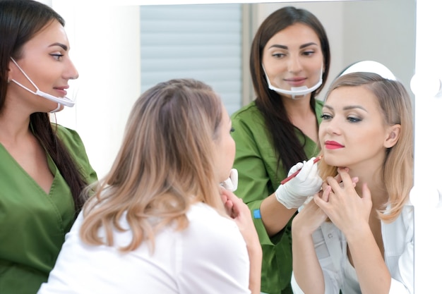 La giovane donna ottiene il trucco. Tatuaggio labbra in un salone di bellezza.