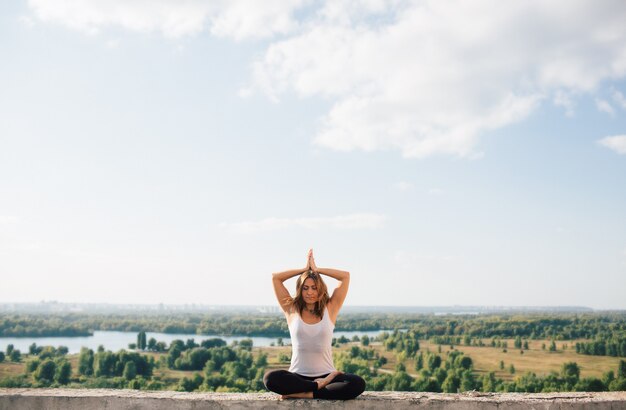 La giovane donna pratica lo yoga all'esterno