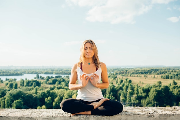 La giovane donna pratica lo yoga all'esterno