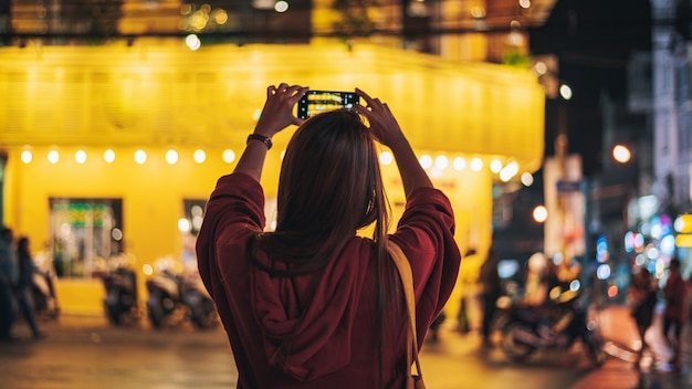 La giovane donna prende una foto dallo Smart Phone e viaggia nella città di notte a Dalat Vietnam