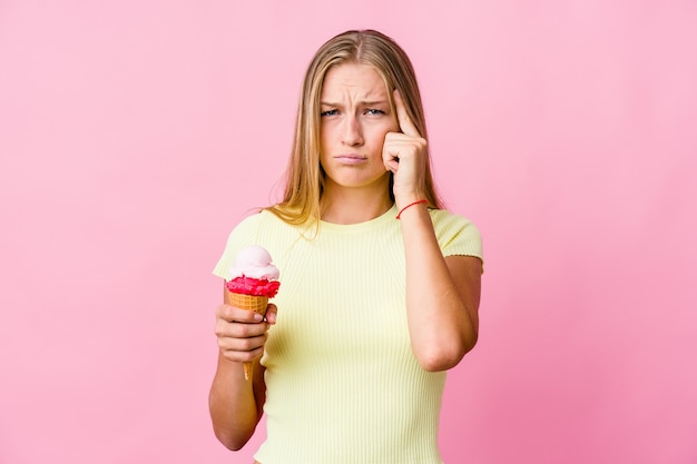 La giovane donna russa che mangia un gelato si è concentrata su un compito, mantenendo gli indici che puntano la testa