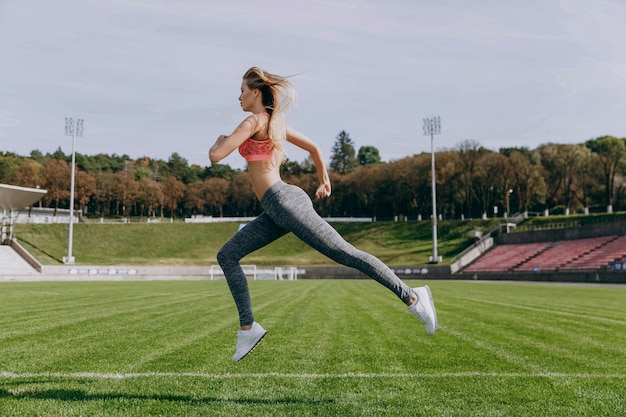 La giovane donna salta correre sullo stadio