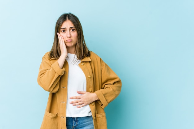 La giovane donna salta le guance, ha un'espressione stanca