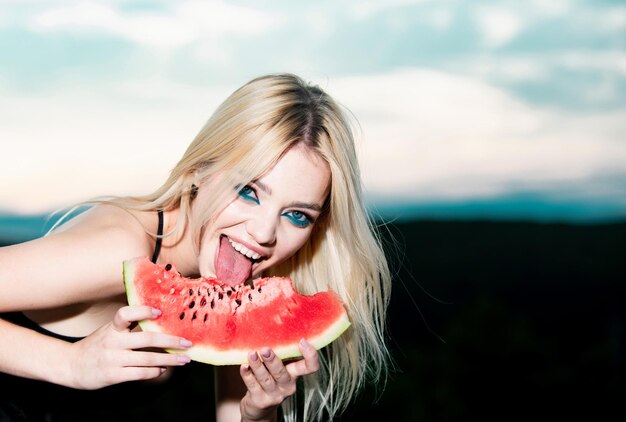 La giovane donna sensuale della frutta tropicale di estate sexy lecca l'anguria con la bella youn divertente della lingua sexy