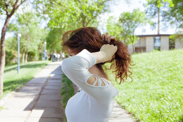 La giovane donna si raddrizza i capelli nel parco