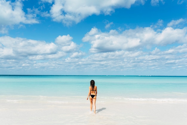 La giovane donna si rilassa sulla spiaggia. Concetto di vacanze.