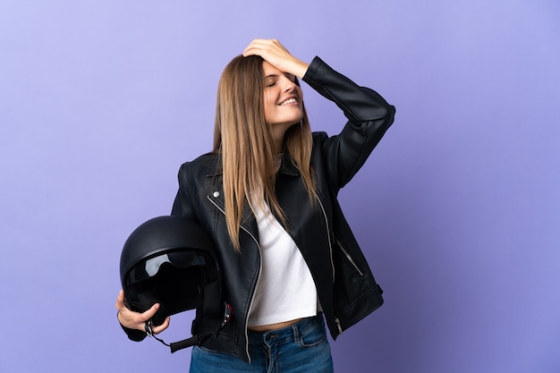 La giovane donna slovacca con in mano un casco da motociclista isolato su viola ha realizzato qualcosa e intende la soluzione