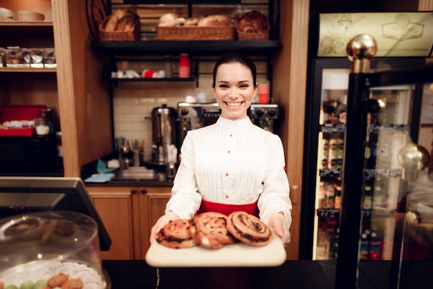 La giovane donna sorridente che sta con Rolls in forno