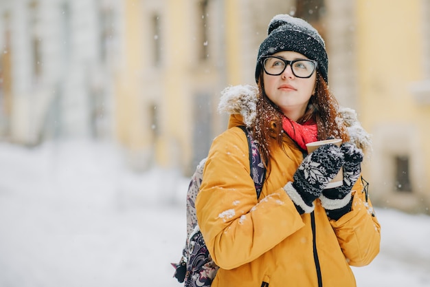 La giovane donna sta camminando per la città. Neve. Concetto Lifestyle, Urban, Winter