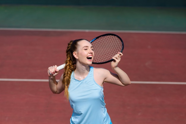 La giovane donna sta giocando a tennis sul campo