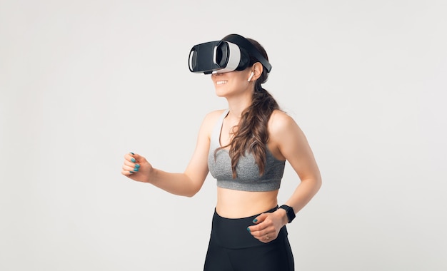 La giovane donna sta guardando alcuni VR in uno studio, sopra fondo bianco.