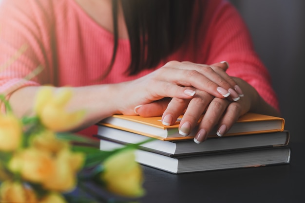 La giovane donna sta leggendo un libro a casa.