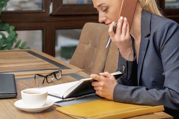 La giovane donna sta parlando al cellulare in ufficio.