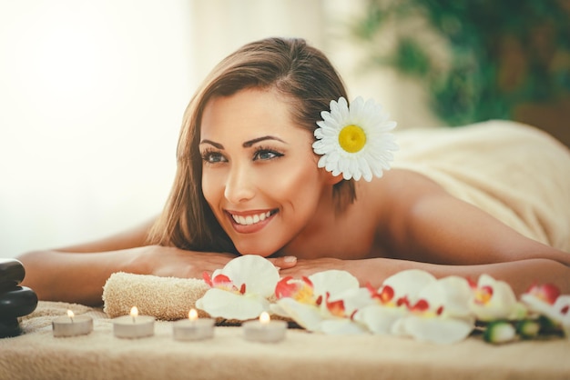 La giovane donna sveglia si sta godendo durante un trattamento per la cura della pelle in una spa.