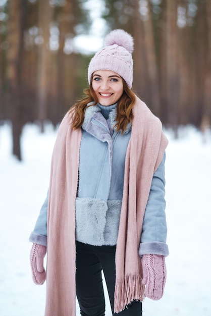 La giovane donna sveglia sta giocando con la neve nella foresta Natura di emozioni di felicità di stile di vita di inverno
