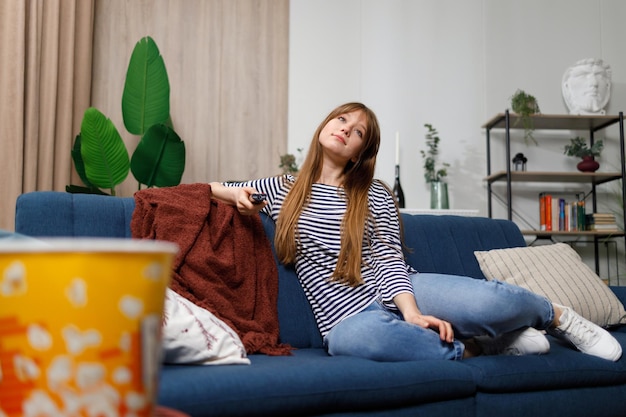 La giovane donna trascorre il suo tempo libero guardando la TV sul divano di casa