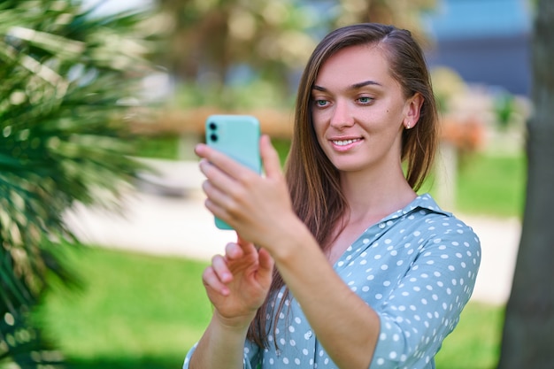 La giovane donna usa lo smartphone all'aperto