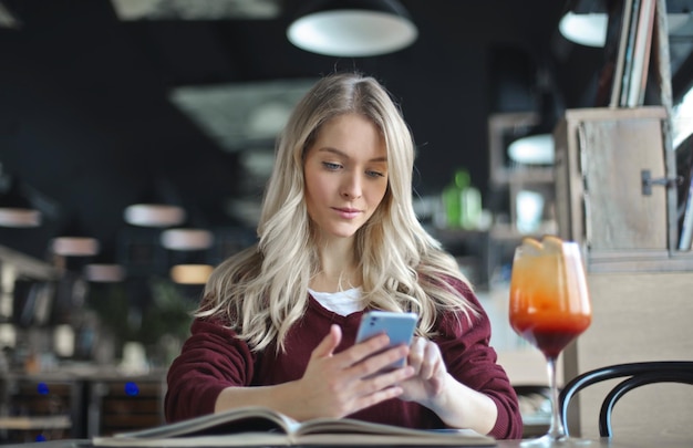 la giovane donna usa uno smartphone in un caffè