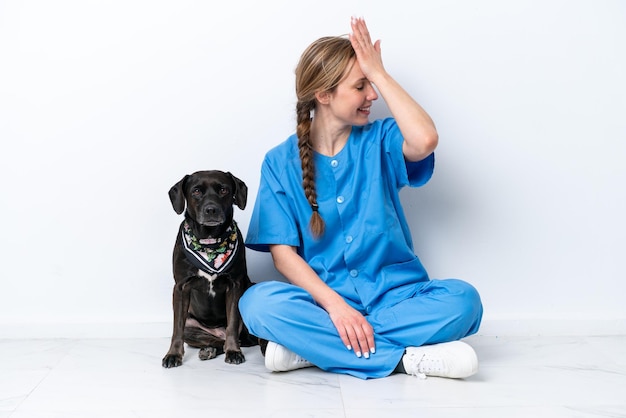 La giovane donna veterinaria con il cane seduto sul pavimento isolato su sfondo bianco ha realizzato qualcosa e intendeva la soluzione