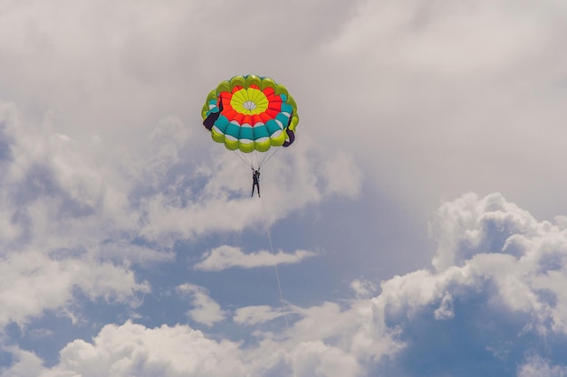 La giovane donna vola su un paracadute tra le nuvole