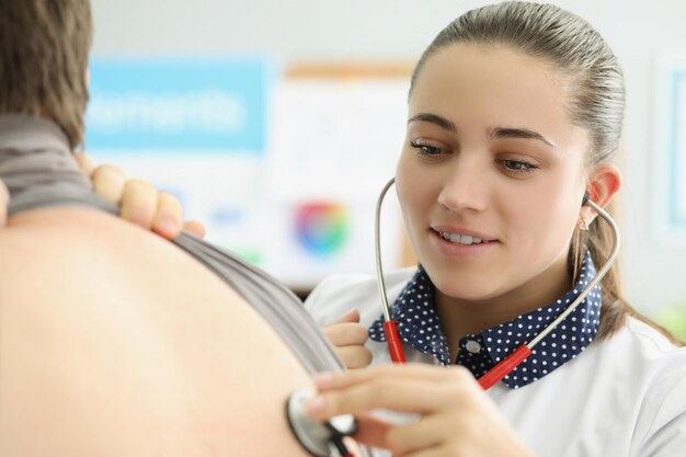 La giovane dottoressa ascolta i pazienti con l'attrezzatura dello stetoscopio