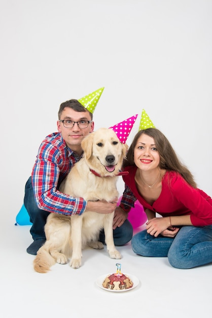 La giovane famiglia con il loro cane golden retriever festeggia un anno di compleanno.