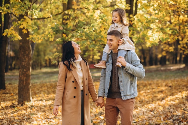 La giovane famiglia felice cammina nel parco autunnale