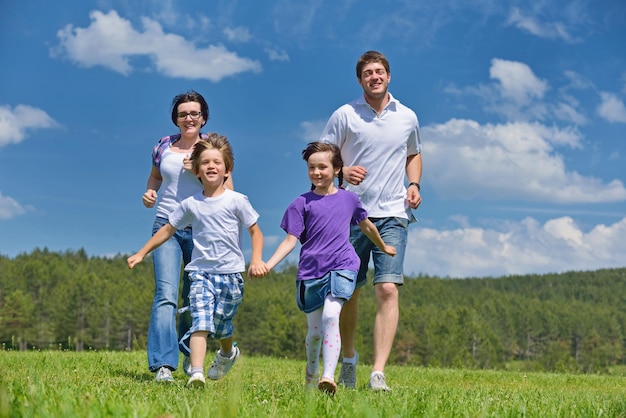 la giovane famiglia felice con i loro bambini si diverte e si rilassa all'aria aperta nella natura con il cielo blu sullo sfondo