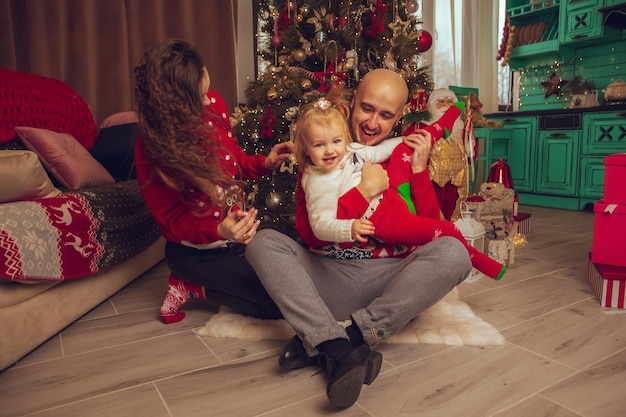 La giovane famiglia felice con la figlia celebra il nuovo anno e il Natale insieme a casa