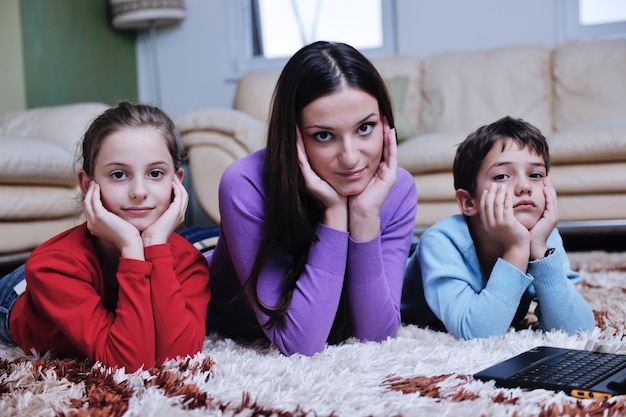 la giovane famiglia felice con mamma e bambini si diverte e gioca nel nuovo soggiorno moderno al coperto