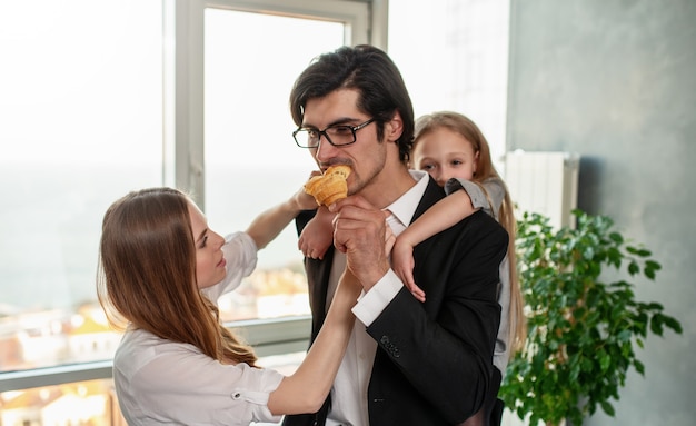 La giovane famiglia felice fa colazione a casa