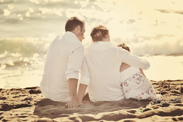 la giovane famiglia felice in abiti bianchi si diverte in vacanza sulla bellissima spiaggia