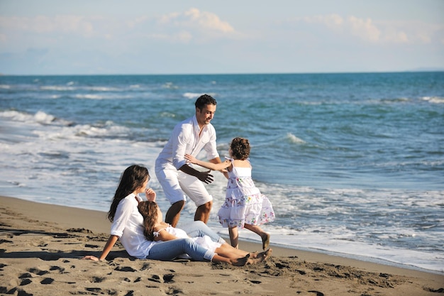 la giovane famiglia felice in abiti bianchi si diverte in vacanza sulla bellissima spiaggia