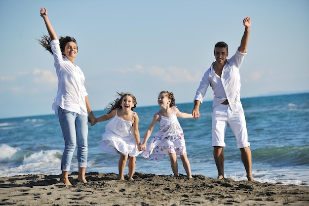 la giovane famiglia felice in abiti bianchi si diverte in vacanza sulla bellissima spiaggia