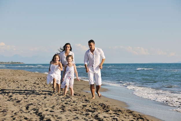 la giovane famiglia felice in abiti bianchi si diverte in vacanza sulla bellissima spiaggia