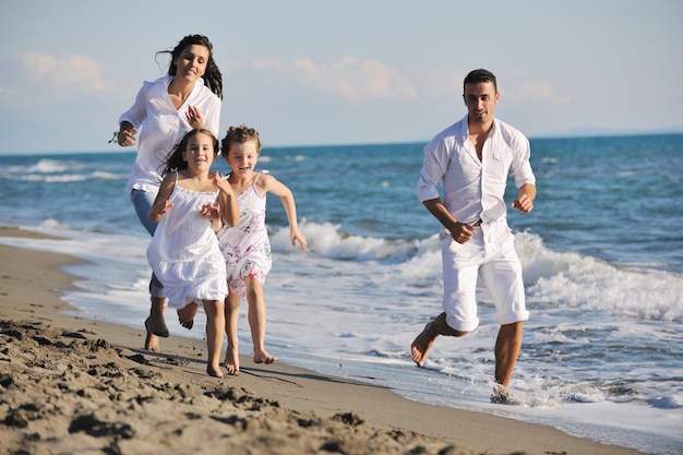 la giovane famiglia felice in abiti bianchi si diverte in vacanza sulla bellissima spiaggia