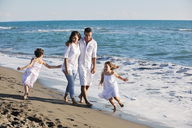 la giovane famiglia felice in abiti bianchi si diverte in vacanza sulla bellissima spiaggia