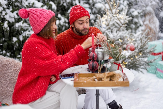 La giovane famiglia ha una cena romantica durante le vacanze invernali all'aperto