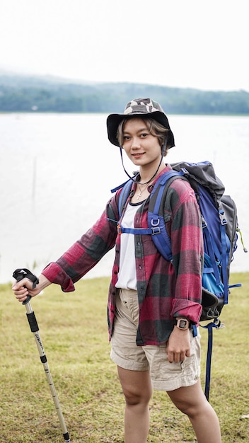La giovane femmina asiatica si prepara per l'escursionismo hipster