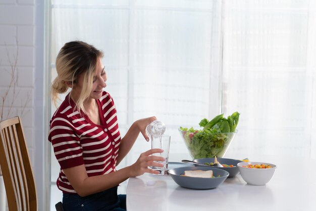 La giovane femmina con acqua potabile pulita che è importante per la sua salute la mantiene libera dalle malattie