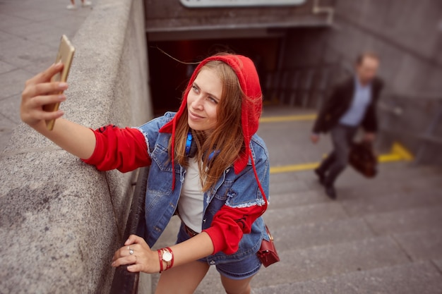 La giovane femmina prende le foto dal telefono cellulare.