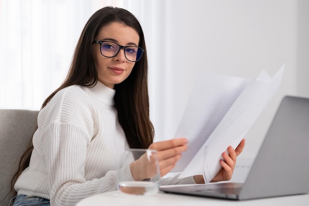 La giovane imprenditrice con gli occhiali lavora con documenti e computer in ufficio