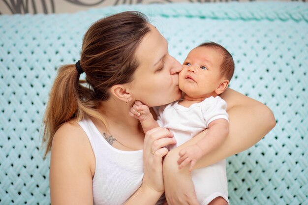 La giovane madre abbraccia delicatamente il suo bambino appena nato