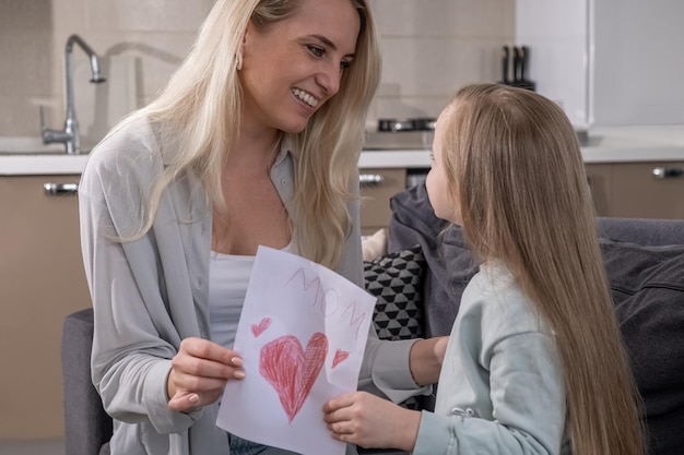 La giovane madre amorevole abbraccia la figlia che le ha dato il compleanno della festa della mamma o della festa della donna