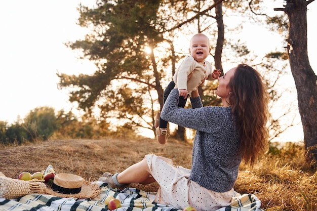 La giovane madre con il suo bambino riposa all'aperto durante la stagione autunnale