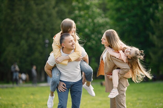 La giovane madre e il padre portano le loro figlie sulle spalle